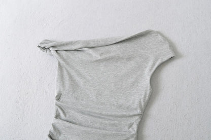 A shirt with a falling shoulder and shirring at the waist