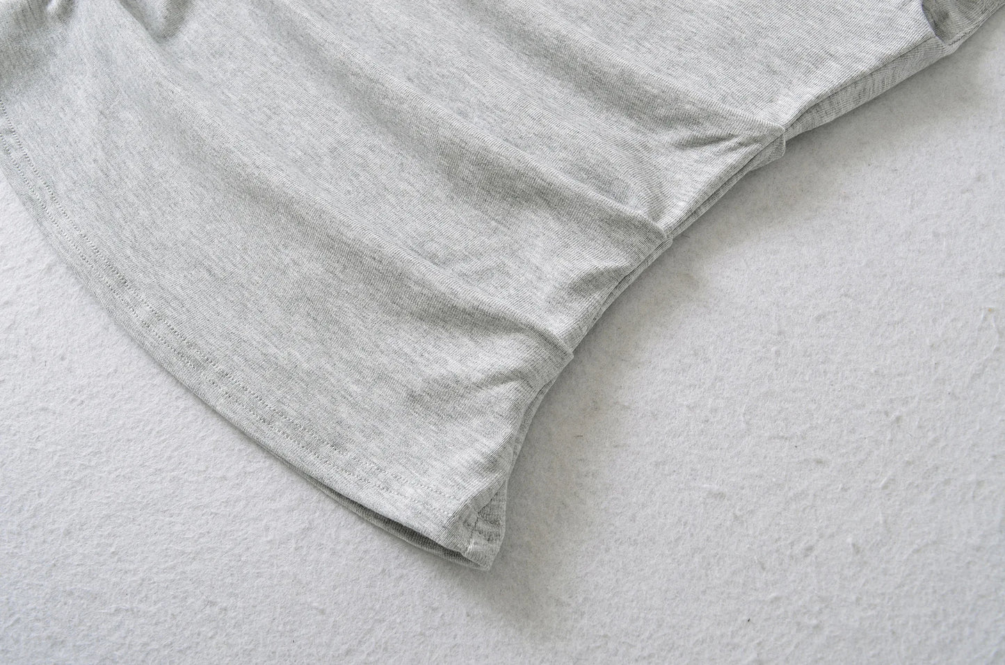 A shirt with a falling shoulder and shirring at the waist