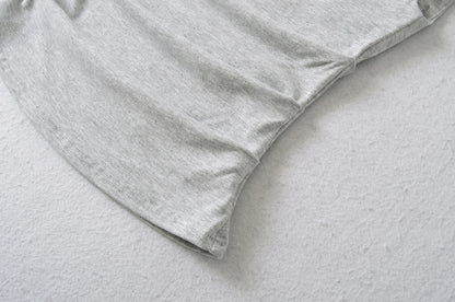 A shirt with a falling shoulder and shirring at the waist